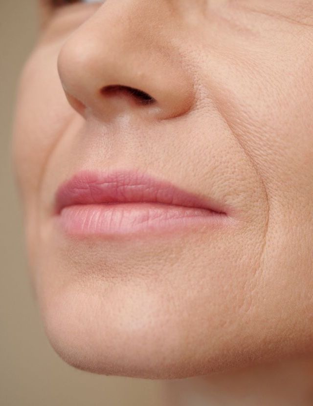 Mulher meia idade com pele regenerada pelo uso di[ario de resveratrol